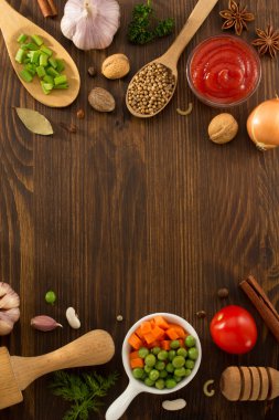 Herbs and spices on wood background clipart