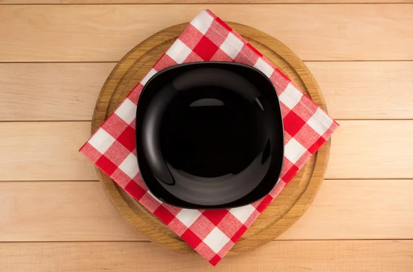 Plate with napkin at cutting board — Stock Photo, Image