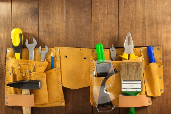 Herramientas e instrumentos en el cinturón sobre madera —  Fotos de Stock