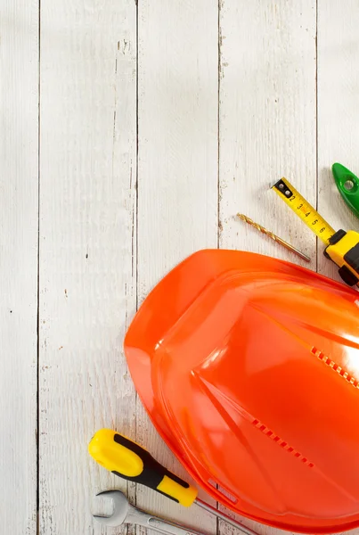 Hardhat and tools on wood — Stock Photo, Image