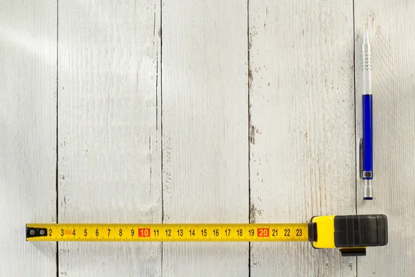 Tape measure and pencil on wood — Stock Photo, Image