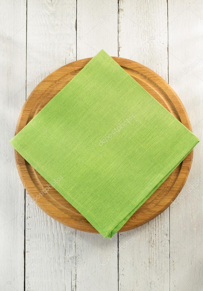 cloth napkin and cutting board on wood