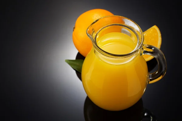 Orangensaft und Früchte auf schwarz — Stockfoto