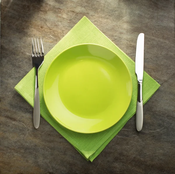 Plate, knife and fork on napkin — Stock Photo, Image
