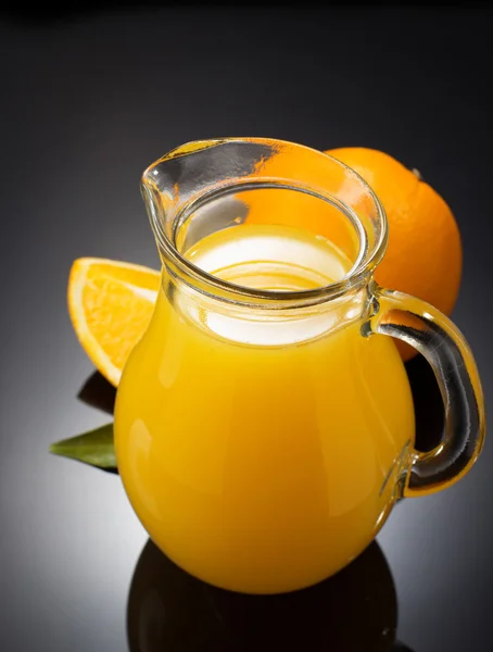 Orange juice and fruit on black — Stock Photo, Image