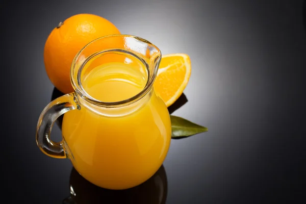 Succo d'arancia e frutta su nero — Foto Stock