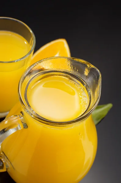 Orange juice och frukt på svart — Stockfoto