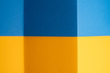Geometrik kağıt kalın mavi ve sarı tonlarda katlanır. Ukrayna bayrağı renkleri. Minimalist Soyut Arkaplan