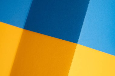 Geometrik kağıt kalın mavi ve sarı tonlarda katlanır. Ukrayna bayrağı renkleri. Minimalist Soyut Arkaplan