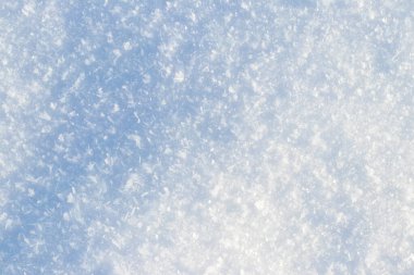 Kış güneşinde ışıl ışıl parlayan buz kristalleriyle kaplı taze kar örtüsünün detaylı soyut arkaplanı, mavi renkli ve yumuşak gölgeler, kış tasarımı ve reklamı için mükemmel.