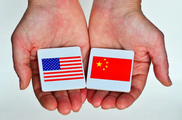 Two hands holds the national flags of the United States of Ameri — Stock Photo, Image