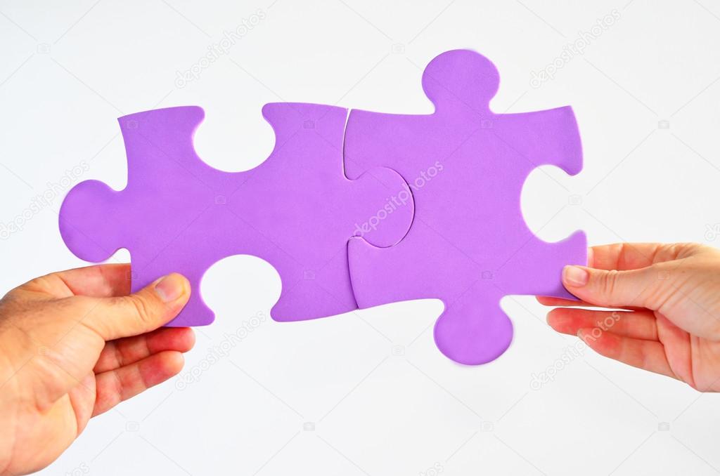 Man and woman hands holds two different jigsaw puzzle pieces con