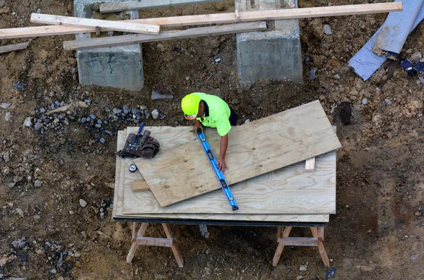 Konstruktion arbetaren åtgärd träbit med linjalen — Stockfoto