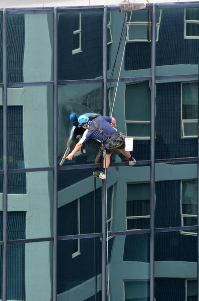 Window cleaner works on high rise building — Stock Photo, Image