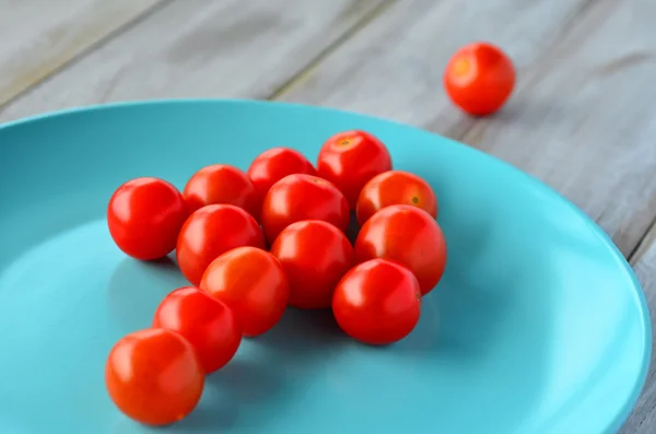 Forma de seta de tomates cereja em uma placa turquesa — Fotografia de Stock