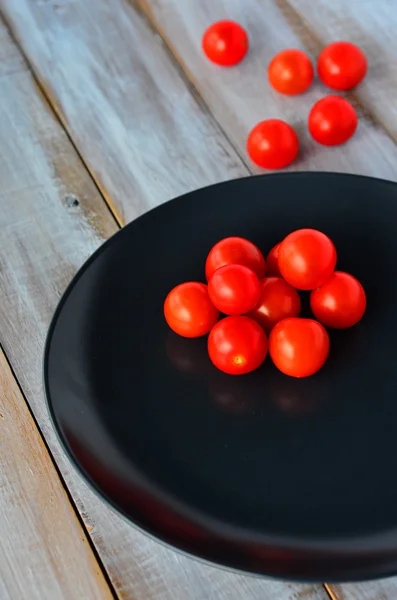 Tomates cherry en un plato negro — Foto de Stock