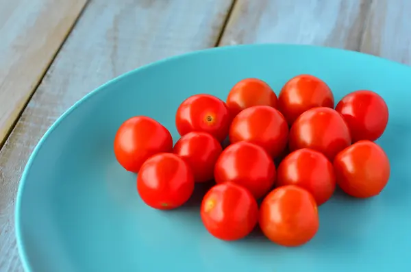 Tomates cherry en un plato de color turquesa — Foto de Stock