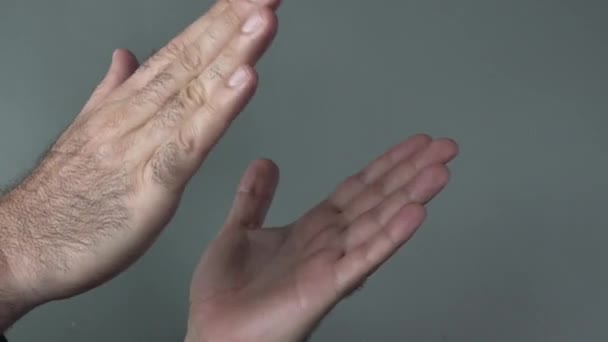 Mãos de homem batendo palmas em um fundo cinza . — Vídeo de Stock