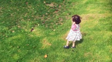 Küçük kız yalnız yeşil çimenlerin üzerinde çalıştırmak