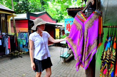 Woman shopping at the Original Rainforest  Market in Kuranda Que clipart