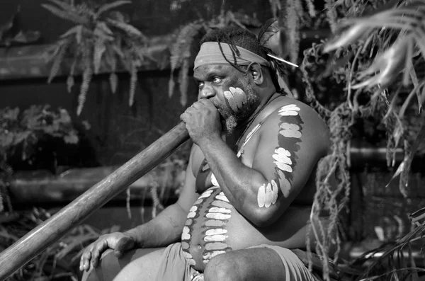 Un homme autochtone joue de la musique autochtone sur didgeridoo — Photo