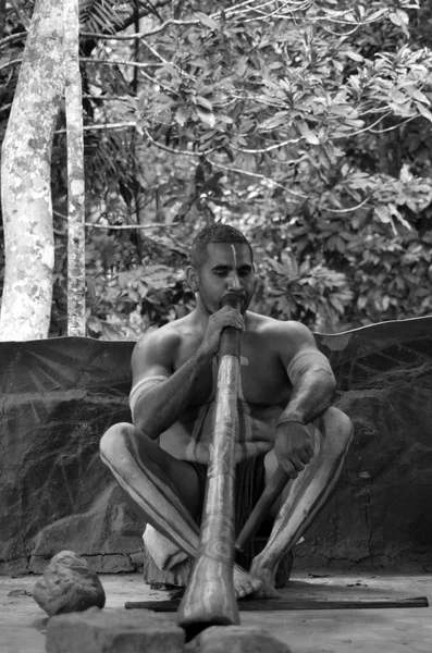El hombre aborigen toca música aborigen en didgeridoo — Foto de Stock