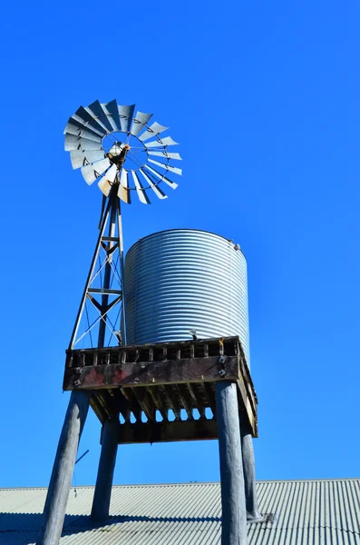 Una vieja bomba de molino de viento australiano y tanque de agua — Foto de Stock