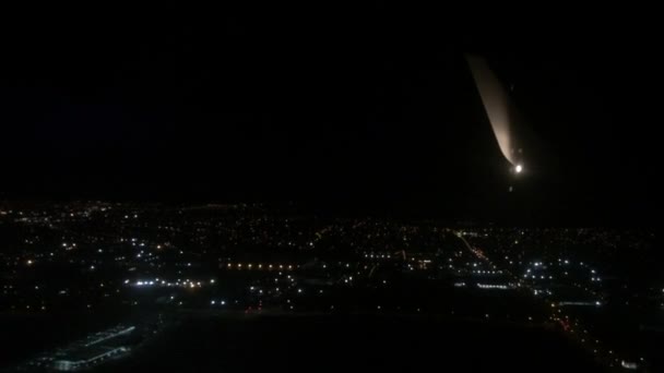 Avión de línea aérea volar por encima de una ciudad por la noche . — Vídeos de Stock