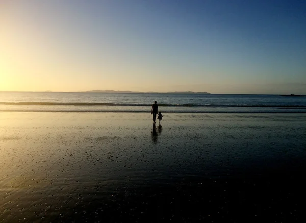 祖母と孫は日没にビーチで散歩します — ストック写真