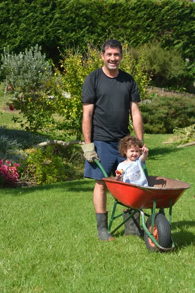 El hombre lleva a su hija en una carretilla — Foto de Stock