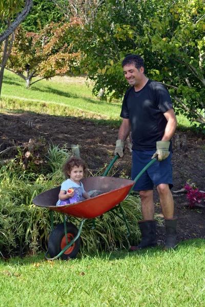 Man carry his daughter in a wheelbarrow — Stock Photo, Image