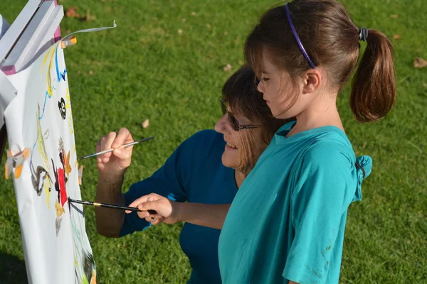 Babička a vnučka malovat společně venkovní — Stock fotografie