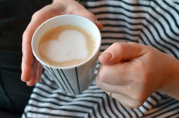 Γυναίκα κατέχει μια κούπα με το καφέ σε σχήμα καρδιάς — Φωτογραφία Αρχείου