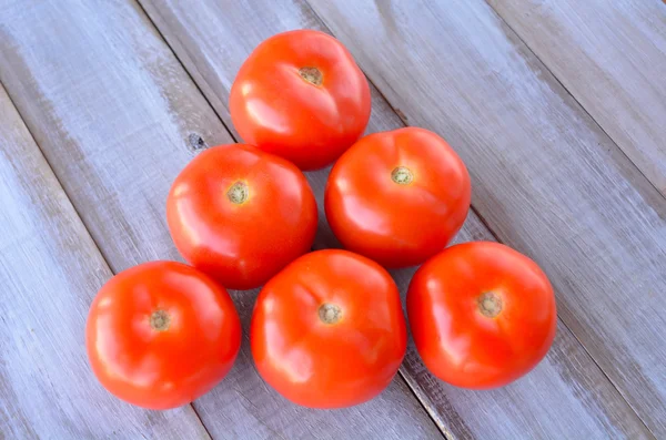 Tomates frescos em uma mesa de madeira — Fotografia de Stock