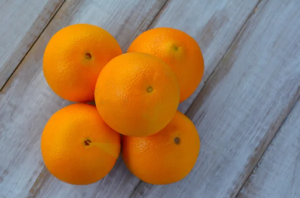 Vijf sinaasappelen op een houten tafel — Stockfoto