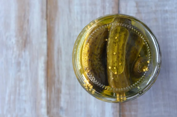 Flat lay of a pickled cucumbers in a glass container — Stock Photo, Image