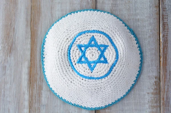 Flat lay of a Knitted kippah with embroidered blue and white Sta — Stock Photo, Image