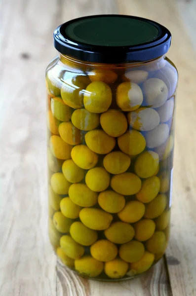Grüne Oliven eingelegt in Glasbehälter — Stockfoto
