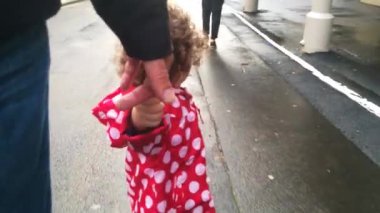 Küçük kız sokakta burada baba ile yürür.