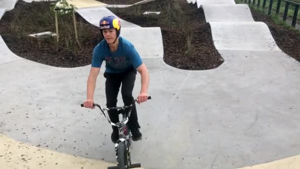 ジャンプを実行するフリー スタイルの Bmx サイクル ライダーによる都市の自転車公園でスタント — ストック動画