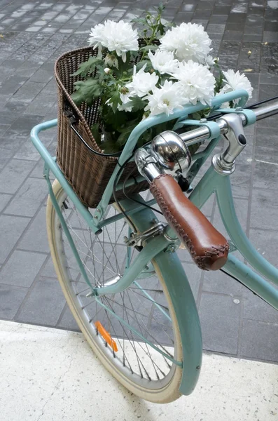 Bicicleta vintage turquesa con una bandeja de flores blancas — Foto de Stock