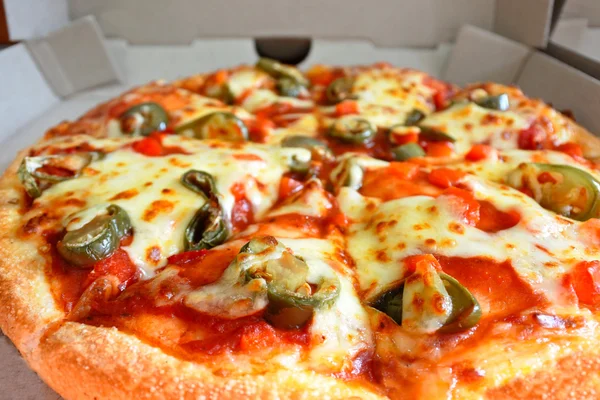 Pizza con guarnizione jalapenos in scatola di cartone — Foto Stock
