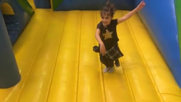 Ung flicka hoppar på bouncing castle — Stockvideo