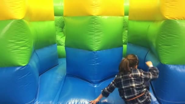 Ung flicka hoppar på bouncing castle — Stockvideo