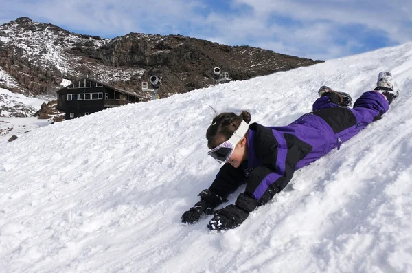 Scivolo bambina sulla neve durante le vacanze invernali — Foto Stock