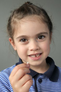 Mutlu genç kız ilk düşen süt dişlerini tutar