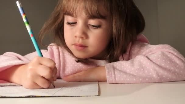 Chica joven escribiendo su tarea — Vídeo de stock