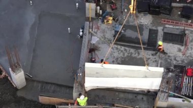 İnşaat İşçileri kılavuzları bir yapı prekast beton içine yerleştirin