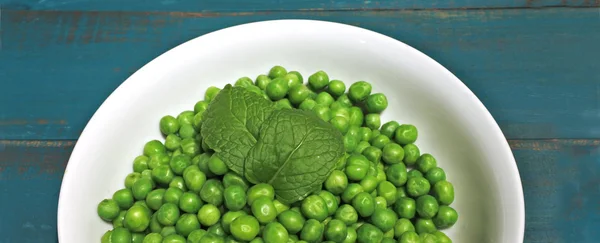 Green peas served in a white bowl — Stock Photo, Image