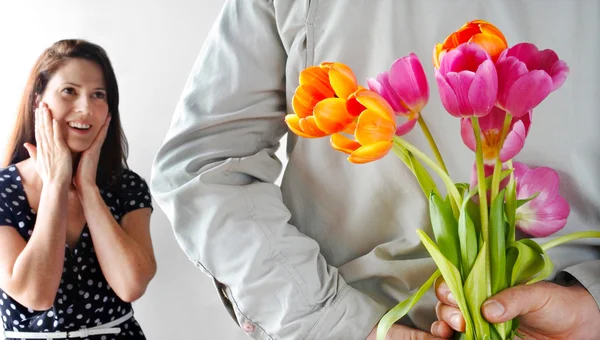 Hesitant woman (age 30-35) receive tulip flowers from her lover. Couple relationship concept.